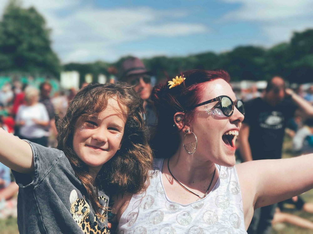 A woman and a girl cheering at a festival